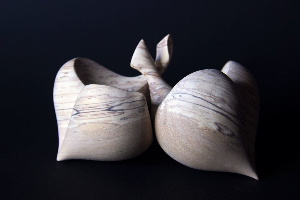 Vue de face de la sculpture tournée "Duo" (sculpture sensorielle et ergonomique dans la main, inspirée par la forme du coeur, en bouleau échauffé) composée de deux éléments dissociables - Création originale de Coralie Saramago