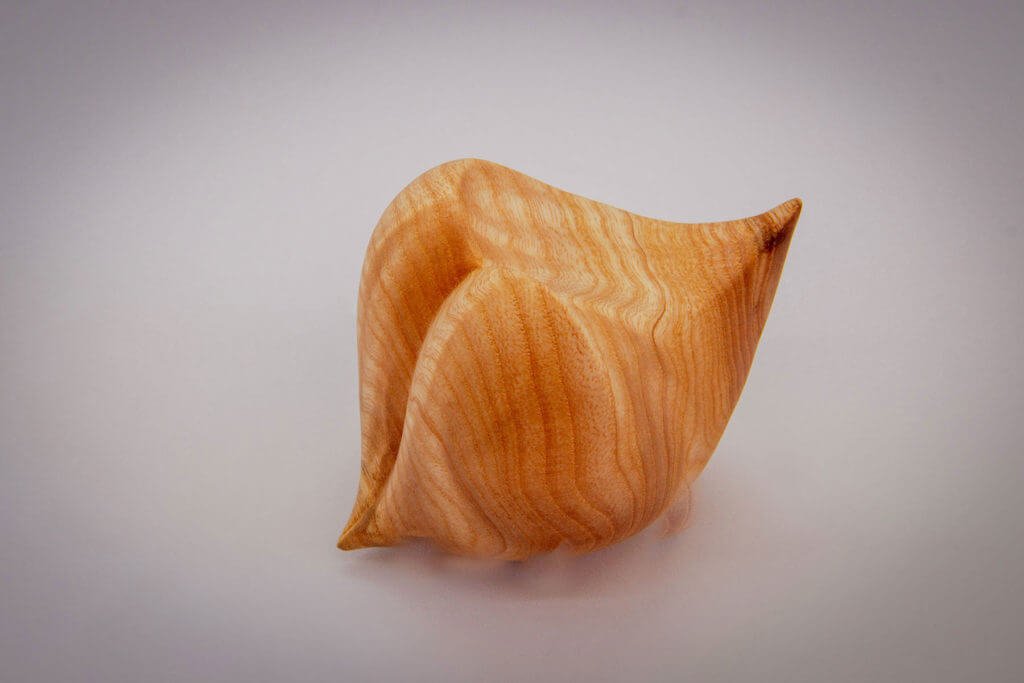 Vue globale de la sculpture tournée : "Graine d'Amour" (sculpture sensorielle et ergonomique dans la main, inspirée par la forme du coeur, en frêne) - Création originale de Coralie Saramago