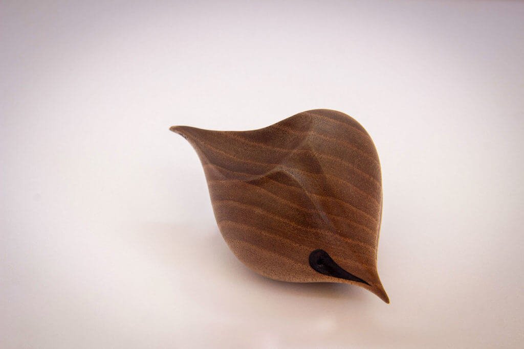 Vue de côté de la sculpture tournée : "Graine d'Amour oiseau" (sculpture sensorielle et ergonomique dans la main, inspirée par la forme du coeur, en noyer foncé) - Création originale de Coralie Saramago